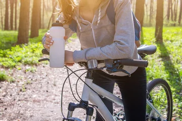 Papier Peint photo Vélo Young woman drinking water after riding a bicycle