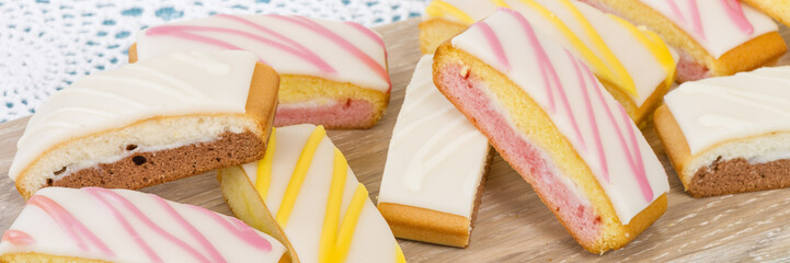 Cake Slices - Variety of colourful cake slices on a wooden board.