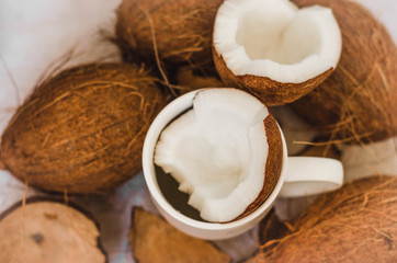 Tasty cocktail in white cup with coconut on table .