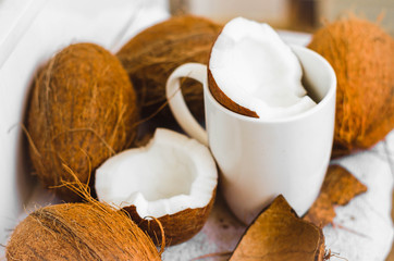 Tasty cocktail in white cup with coconut on table .
