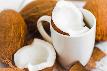 Tasty cocktail in white cup with coconut on table .