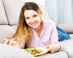 Obraz na płótnie Canvas Woman tasting fresh green salad