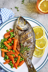 Baked dorado or sea bream with spring vegetables.Top view.