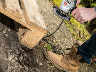 Man sanding a wooden palette