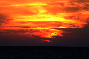 Fototapeta na wymiar sunset in winter, cloudy sky, sun ray in the sea of clouds