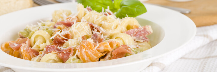 Trottole Tricolore Panna e Prosciutto - Italian tricolour pasta with creamy sauce and parma ham garnished with parmigiano reggiano.