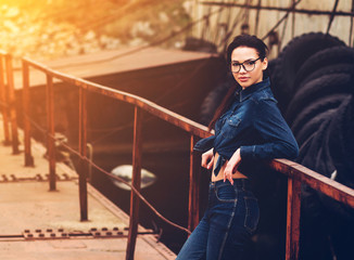 portrait of girl in trendy glasses and a denim shirt urban place