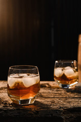 Glass of whiskey on wooden background close up