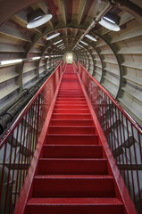 Red staircase in a round metal tunnel