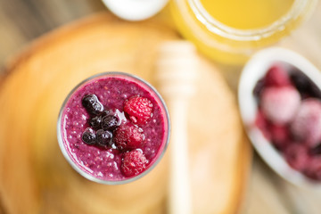 Raspberries, blueberries chia smoothie with touch of honey, served in a tall glass