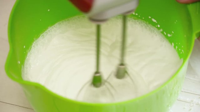 Woman's hands prepering the cream for the eclairs with mixer