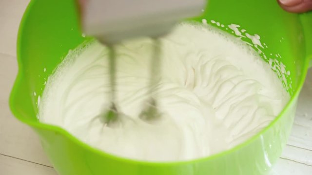 Woman's hands prepering the cream with mixer