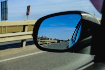 Fototapeta premium look in the rear view mirror of a car 