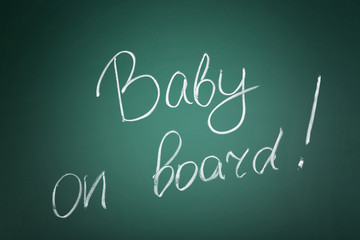 Text BABY ON BOARD written on chalkboard