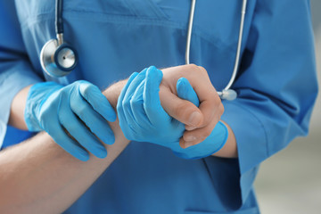 Medical assistant examining patient's arm in clinic, closeup