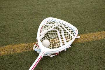Goalies lacross stick with a ball in the net