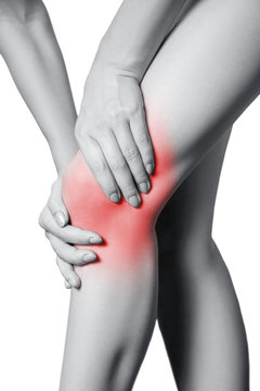 Closeup view of a young woman with knee pain. isolated on white background. Black and white photo with red dot.