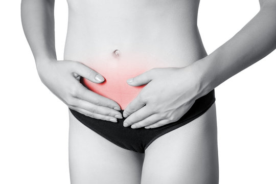 Closeup view of a young woman with stomach pain or digestion or period cycle . isolated on white background. Black and white photo with red dot.