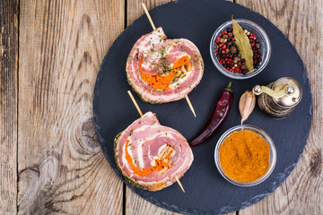 Roll of pork with spices for grilling on black stone