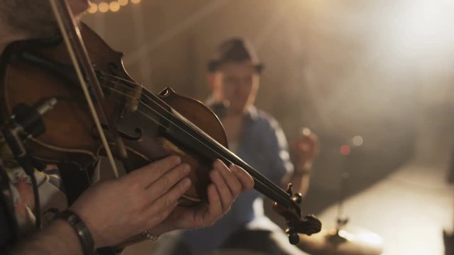 Three Young Men Playing Bas Guitar, Rattle and a Violin