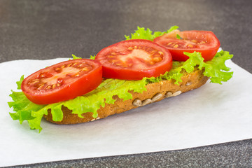 Sandwich with sausage and vegetables on whole grain bread