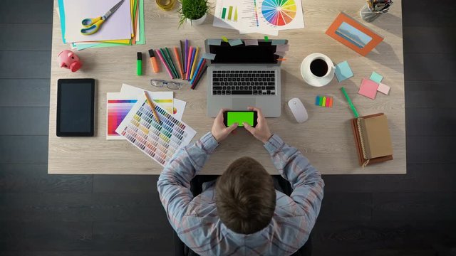 Designer typing message on green screen gadget, appointing meeting with client