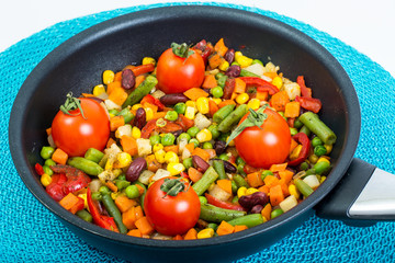 Steamed vegetables with tomatoes in pan