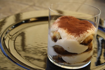Traditional Italian made tiramisu cake, in glass cup.