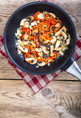 Fried mushrooms with peppers and onions in the pan. View from ab