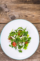 Cooked squid, fresh arugula, tomatoes, oil, spices