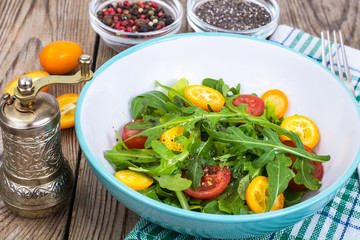 Vegetarian salad with arugula, kumquats and tomatoes