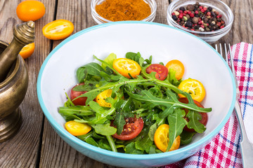 Vegetarian salad with arugula, kumquats and tomatoes
