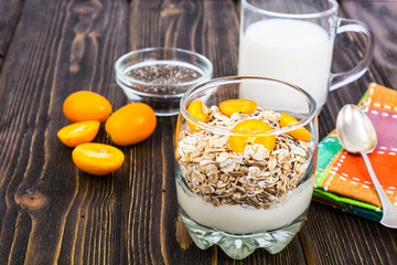 Healthy breakfast, oatmeal with kumquats, granola, yoghurt, chia