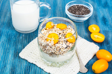 Healthy breakfast, oatmeal with kumquats, granola, yoghurt, chia