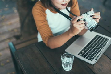 Woman looking at camera's monitor checking pictures taken.