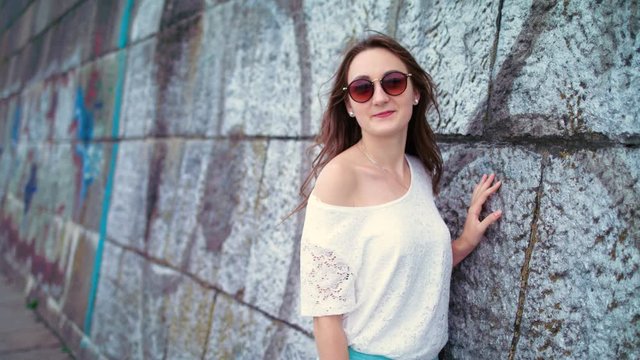 Young pretty girl in sunglasses posing and looking at the camera. Portrait shot. woman having fun