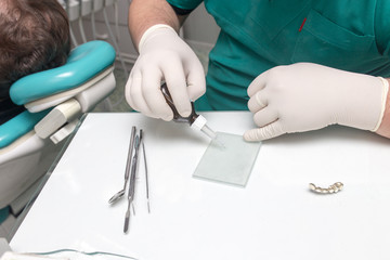 A dentist prepares an implant in the clinic