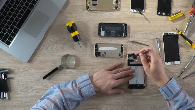 Skilled service worker using screwdriver undoing broken part to replace it