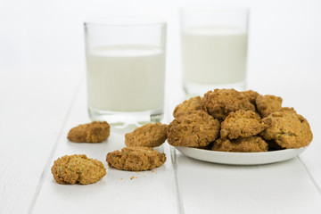 Milk in two glasses and bowl with homemade biscuits.