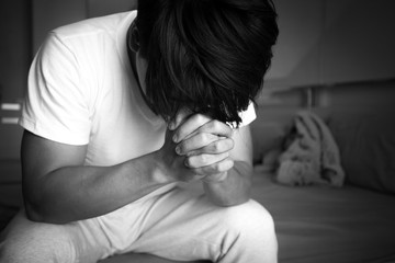 Asian man with sad mood in the room, sadness portrait concept, black and white tone.