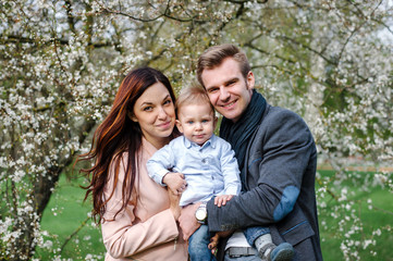 Fototapeta premium Happy young family walking in a city park