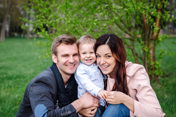 Happy young family walking in a city park