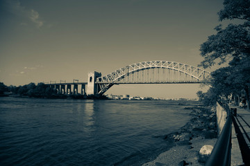 The Hell Gate Bridge and the shore in vintage style at Astoria Park, New York