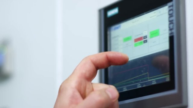 Industry control screen display. Monitor touch screen hand. Factory control system screen. Close up of control monitor system. Male hand touch control screen display. Industrial computer equipment