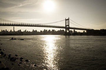 Silhouette of Triborough bridge over the river and the city in vintage style, New York