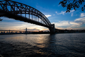 Silhouette of Hell Gate Bridge and Triborough bridge over the river, New York