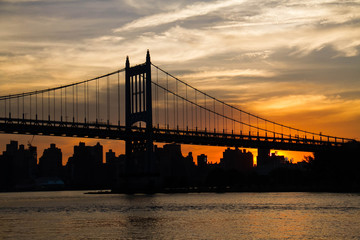 Triborough bridge and city with cloudy sunset sky, New York