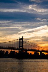 Triborough bridge and city with cloudy sunset sky, New York