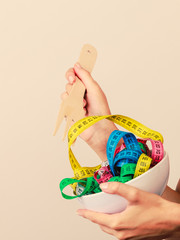 Diet. human hand and measuring tapes in bowl