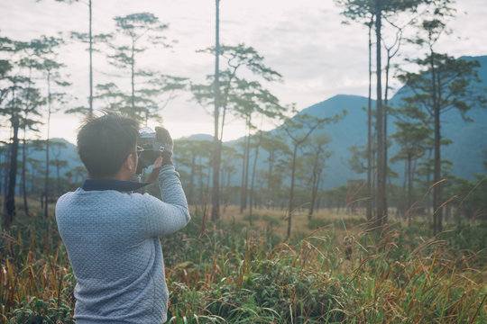 Man taking photos of landscape in the forest at Phu Soi Dao, Uttaradit, Thailand.